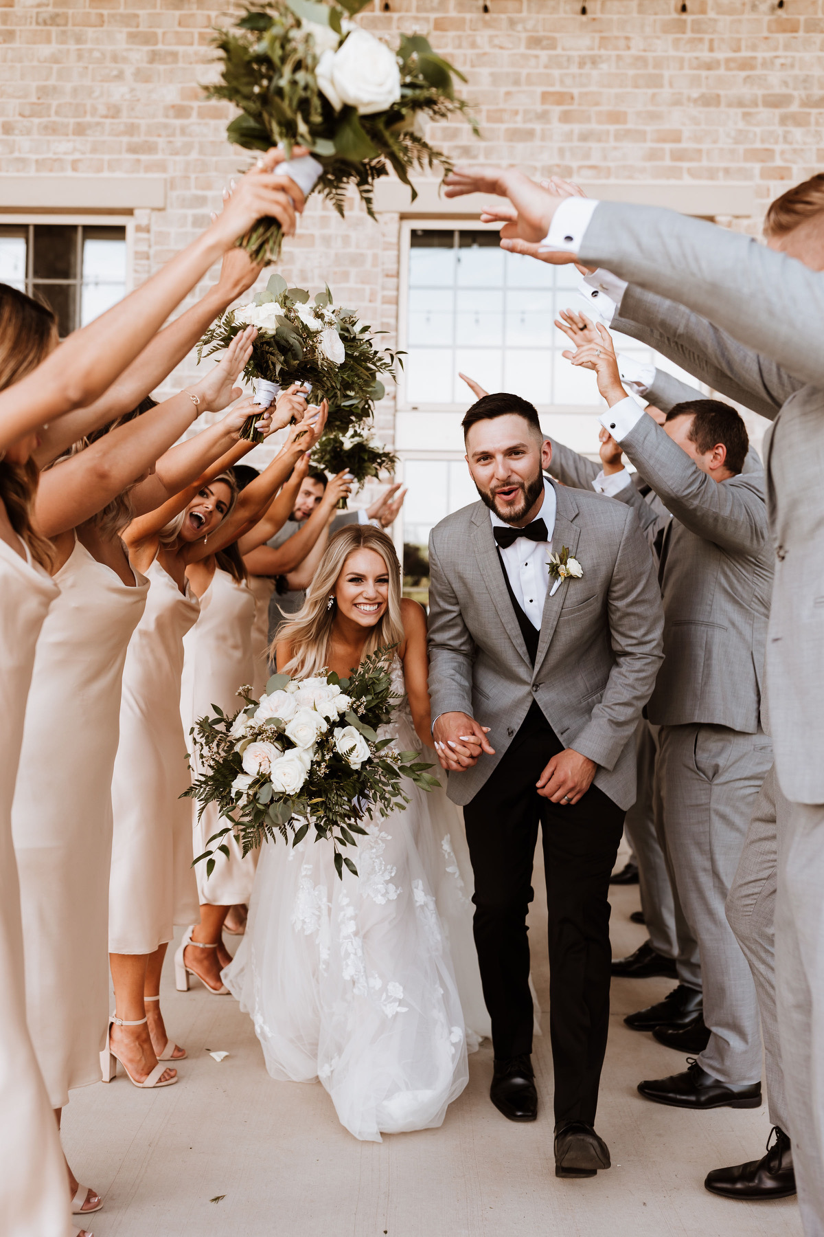 bride and groom walking between files of party guests